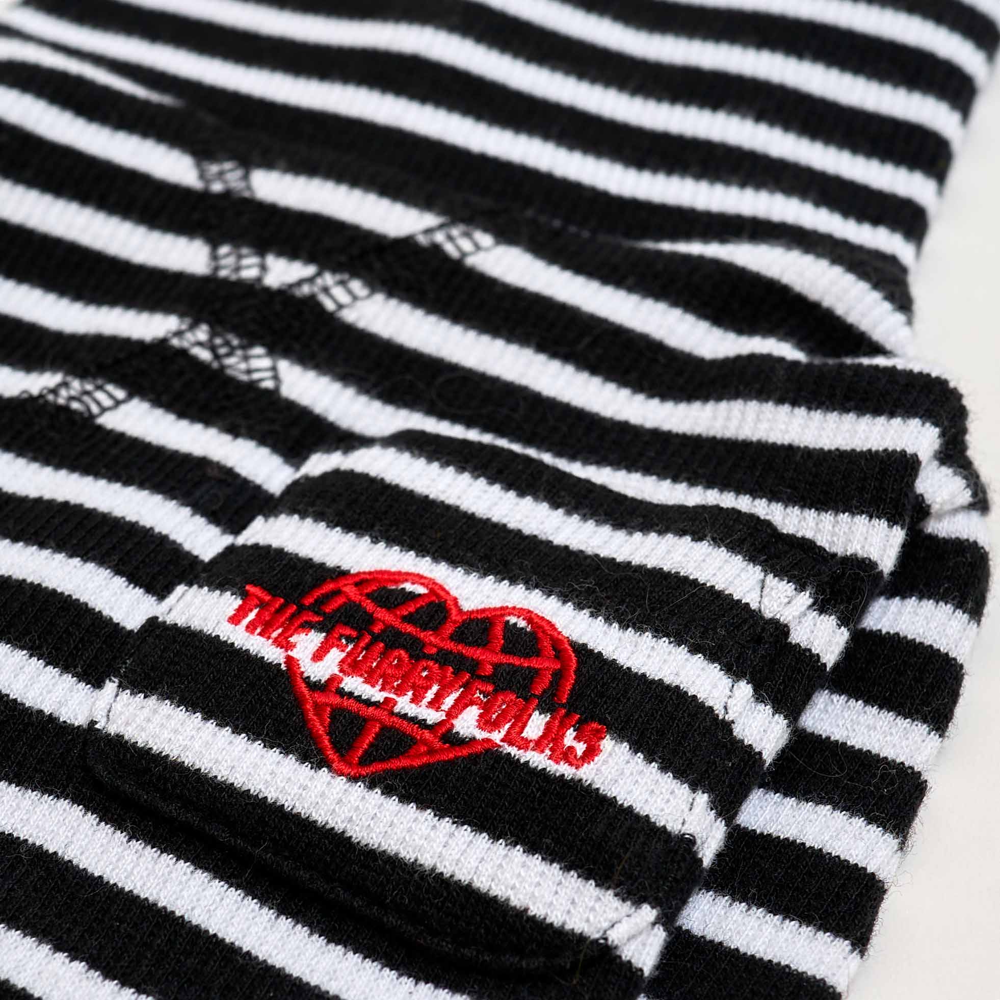 Close-up of a black and white striped dog shirt sleeve featuring a red heart and 'THE FURRYFOLKS' logo embroidery.