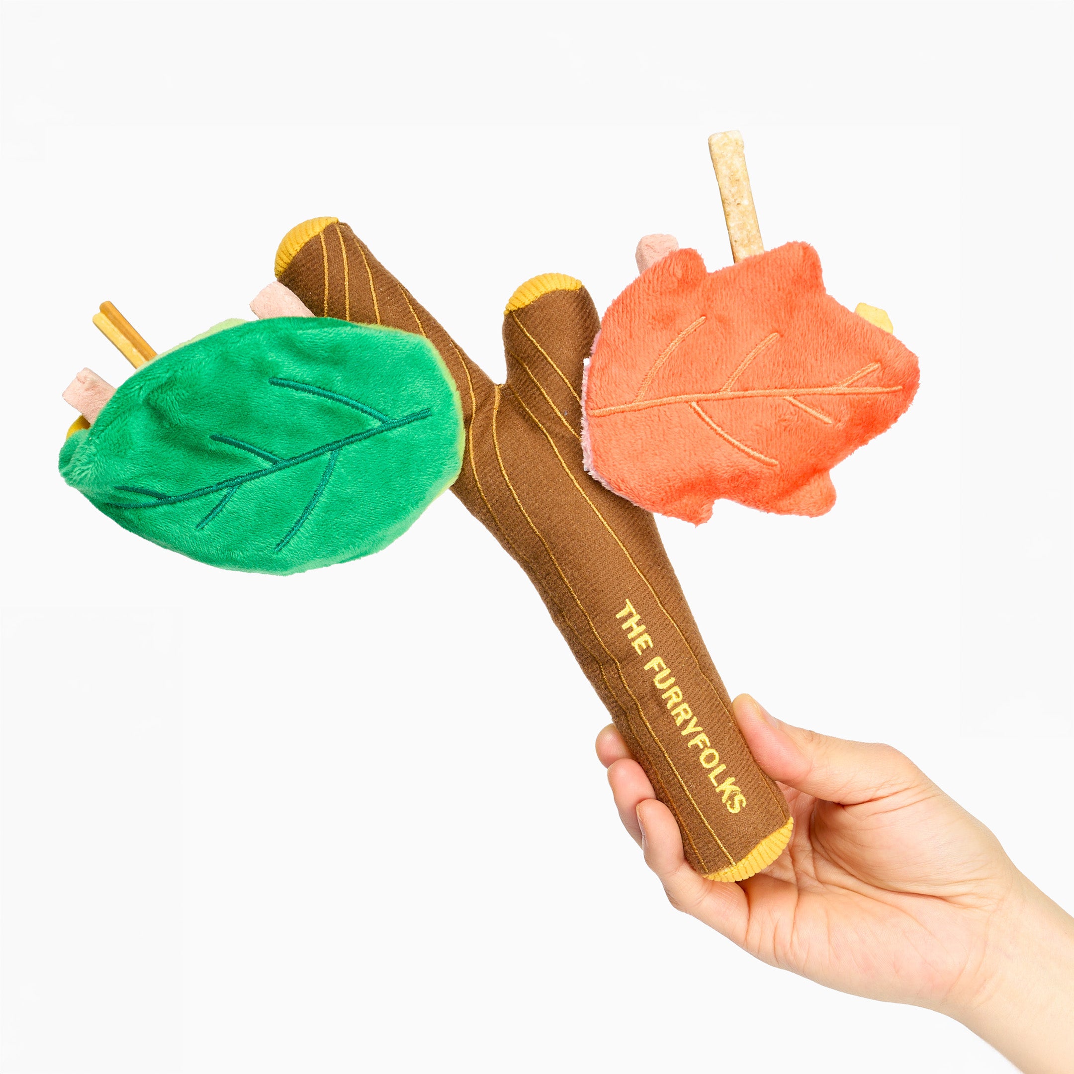 Hand holding a leaf-shaped toy with 'The Purrfect' branding on a white background