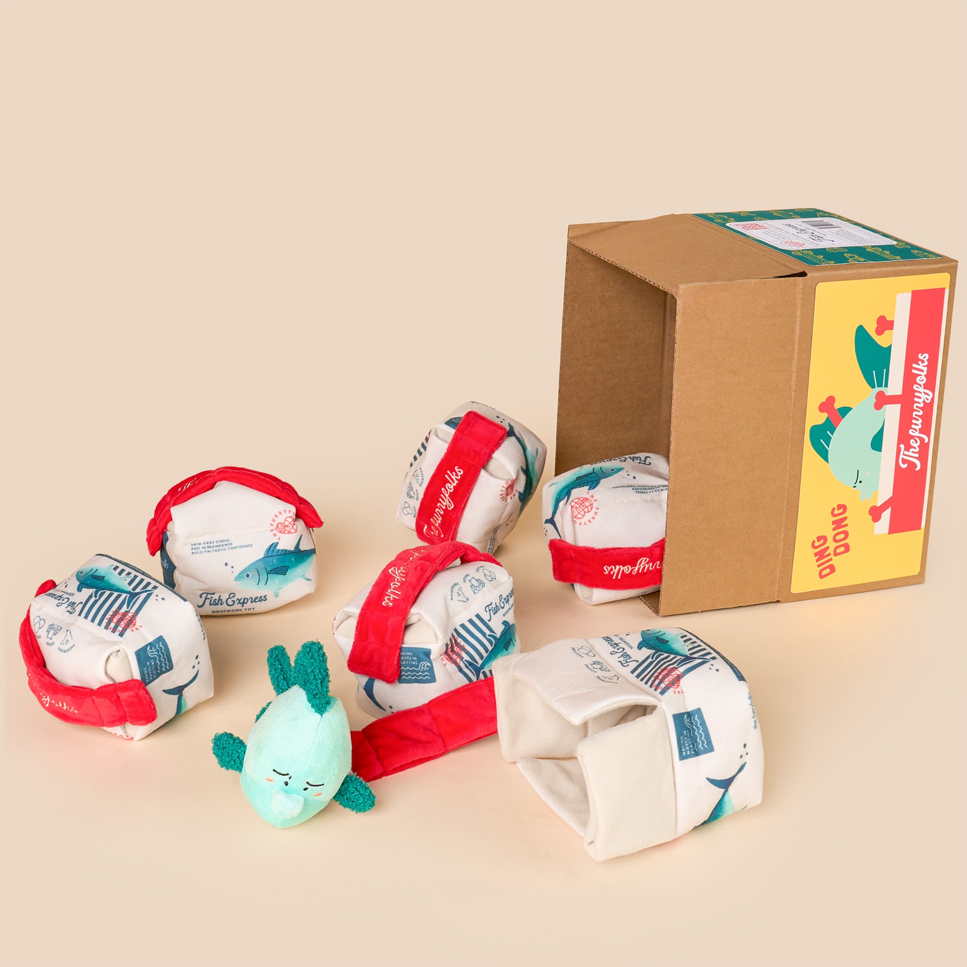 Set of plush toys resembling tortoises with a cardboard box on a beige background