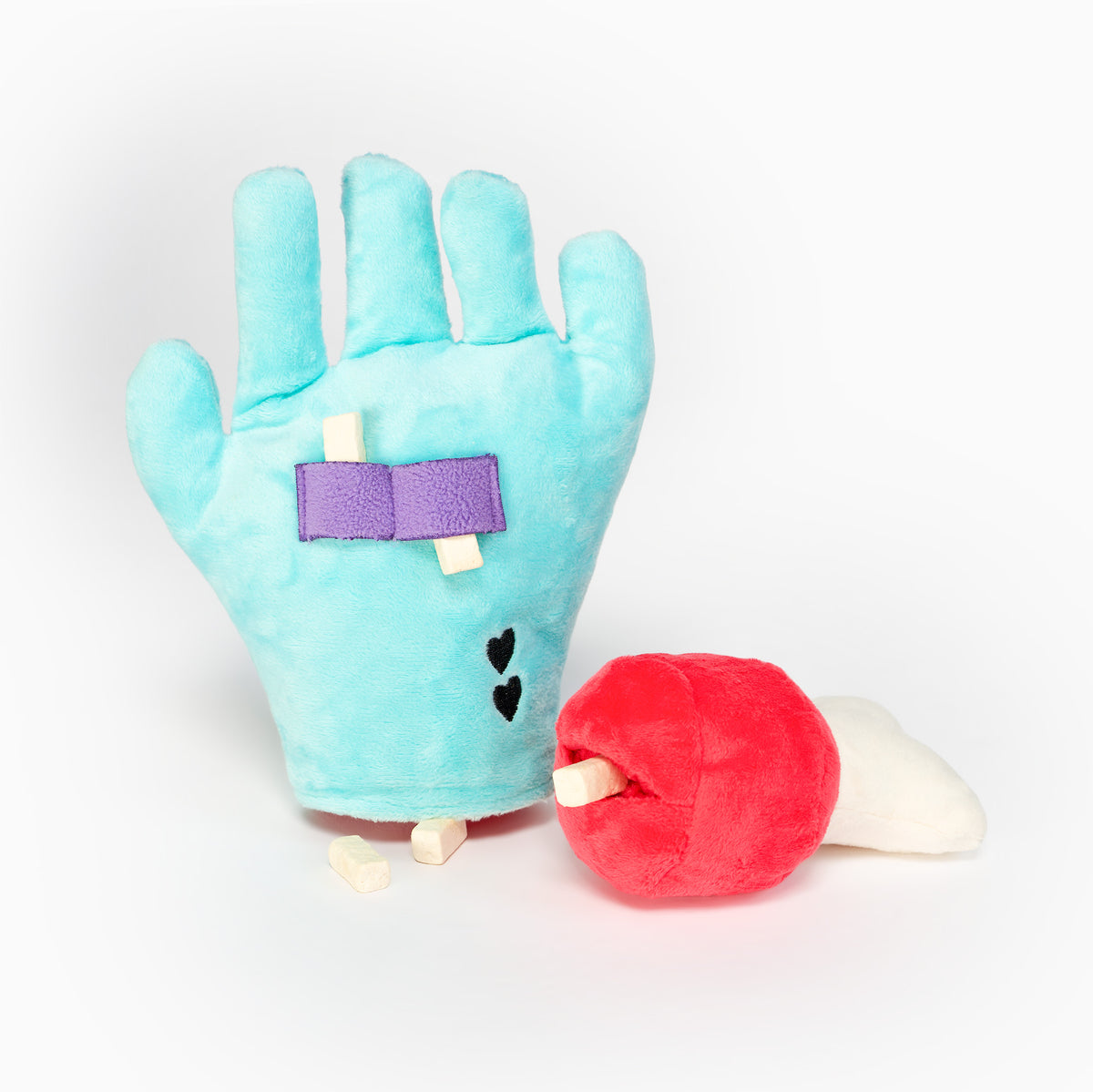 Palm side of the Lost Hand toy showing treats beneath purple straps, beside the removable bone with a treat in its pocket.