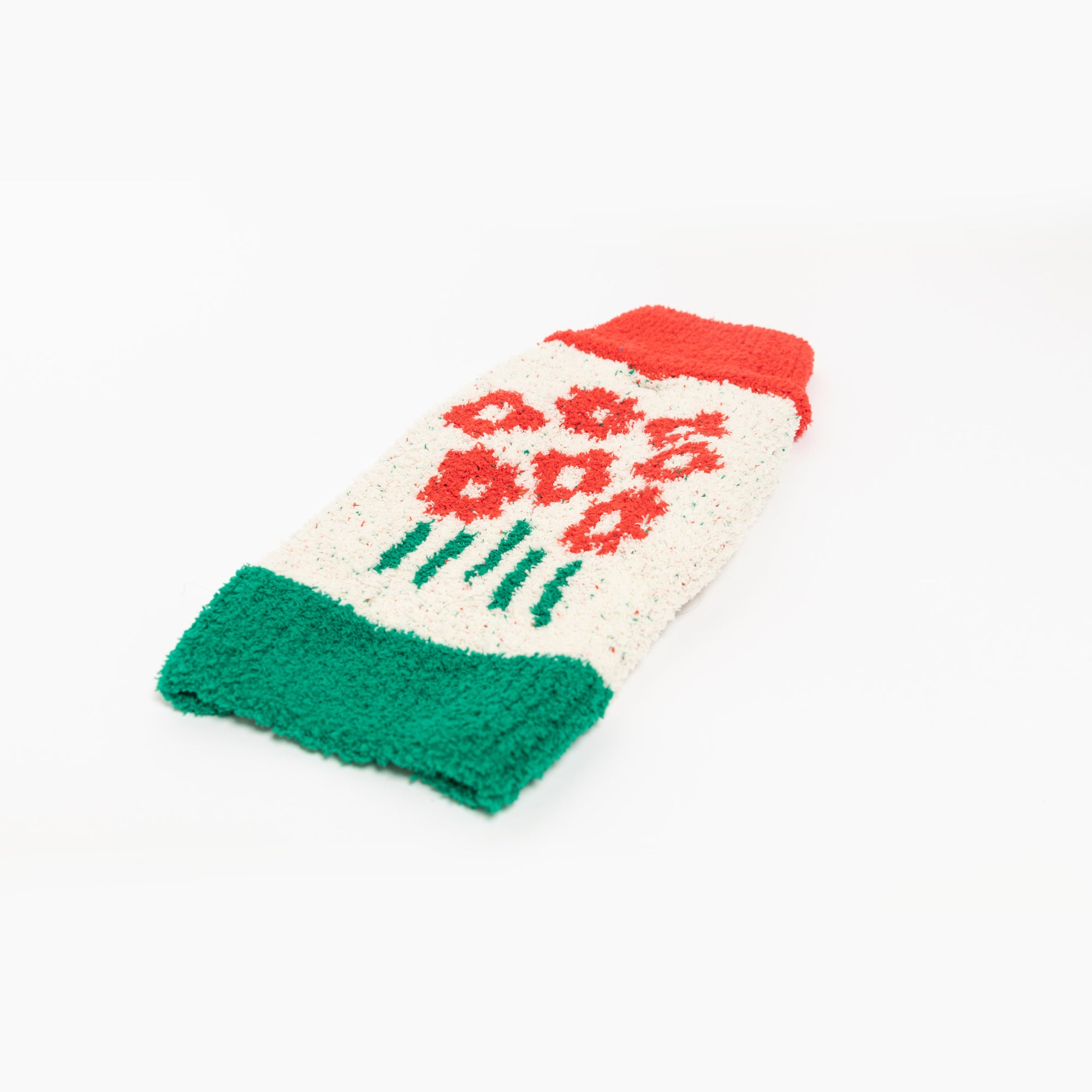  "The Furryfolks" sweater with a flower pattern in red and green, laid out on a white surface.