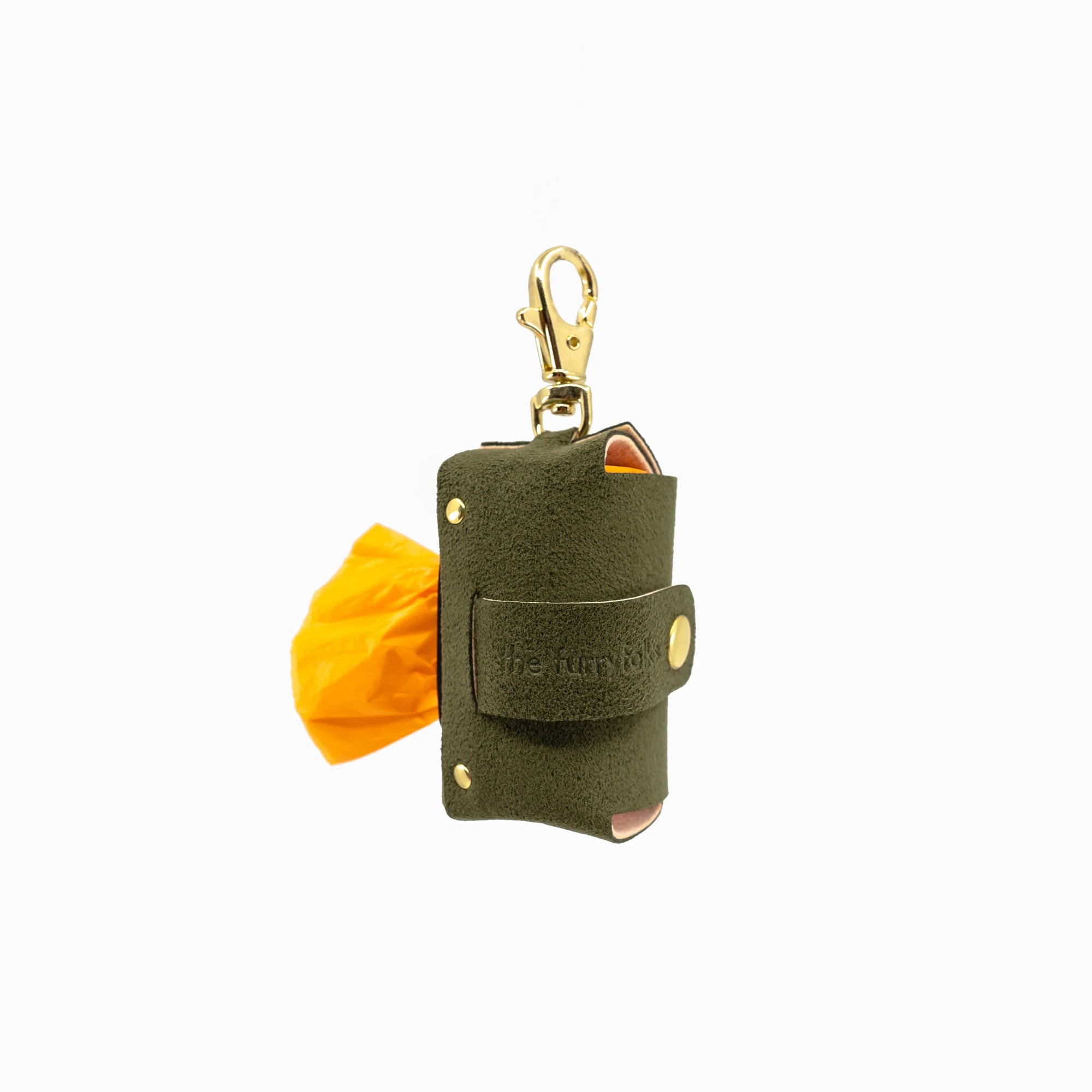 The photo shows an olive green dog poop bag holder marked with "the furryfolks" brand, featuring a gold clip and a roll of yellow bags. It's a practical accessory for pet owners to handle waste during walks.