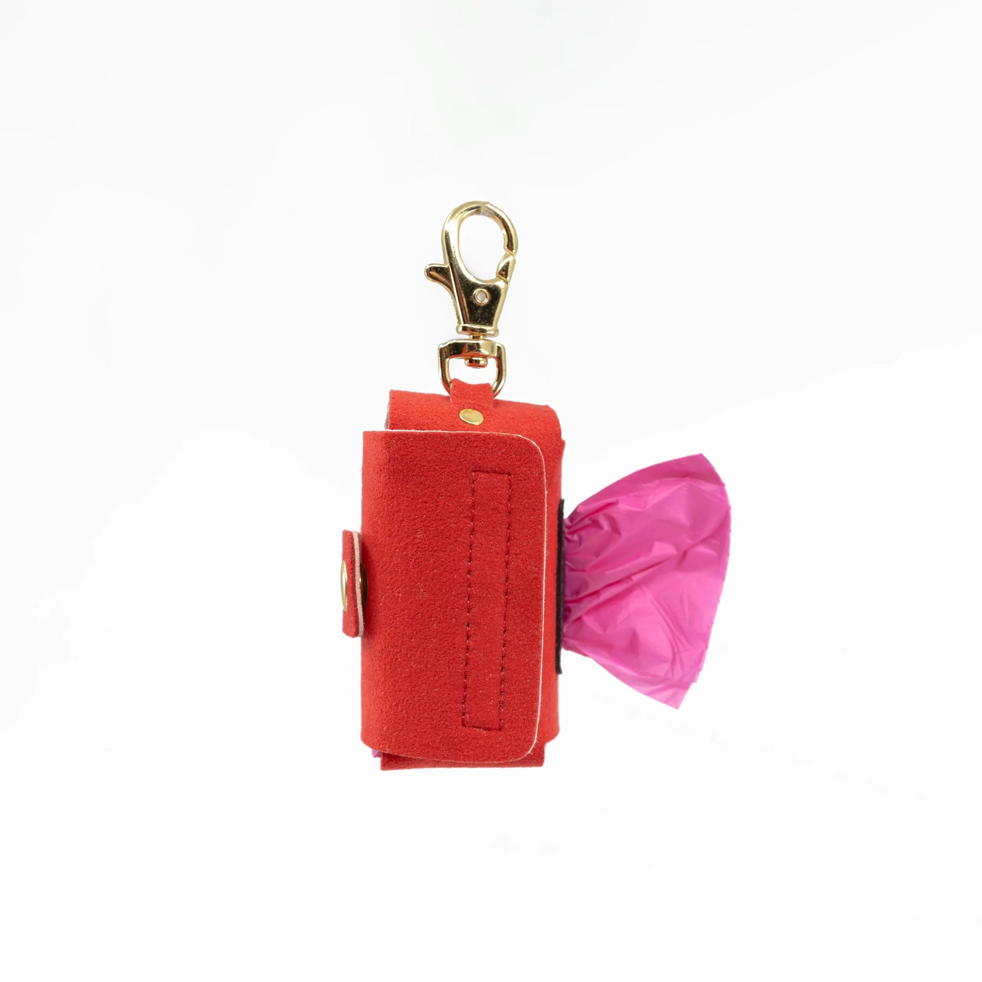 The photo showcases a red dog poop bag holder with a roll of pink bags, equipped with a gold clip for easy leash attachment. It's a part of "the furryfolks" product line, emphasizing convenience for dog owners during walks.